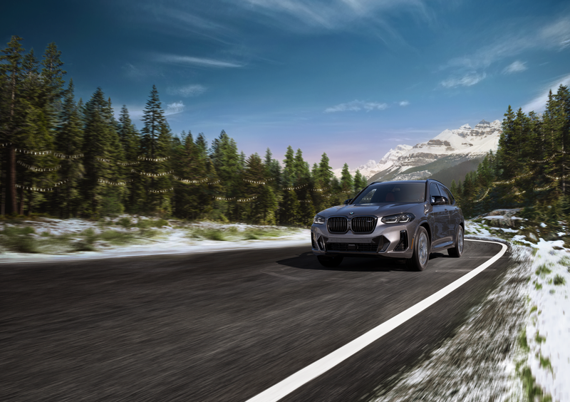 2022 BMW X3 driving down a scenic road lined with trees