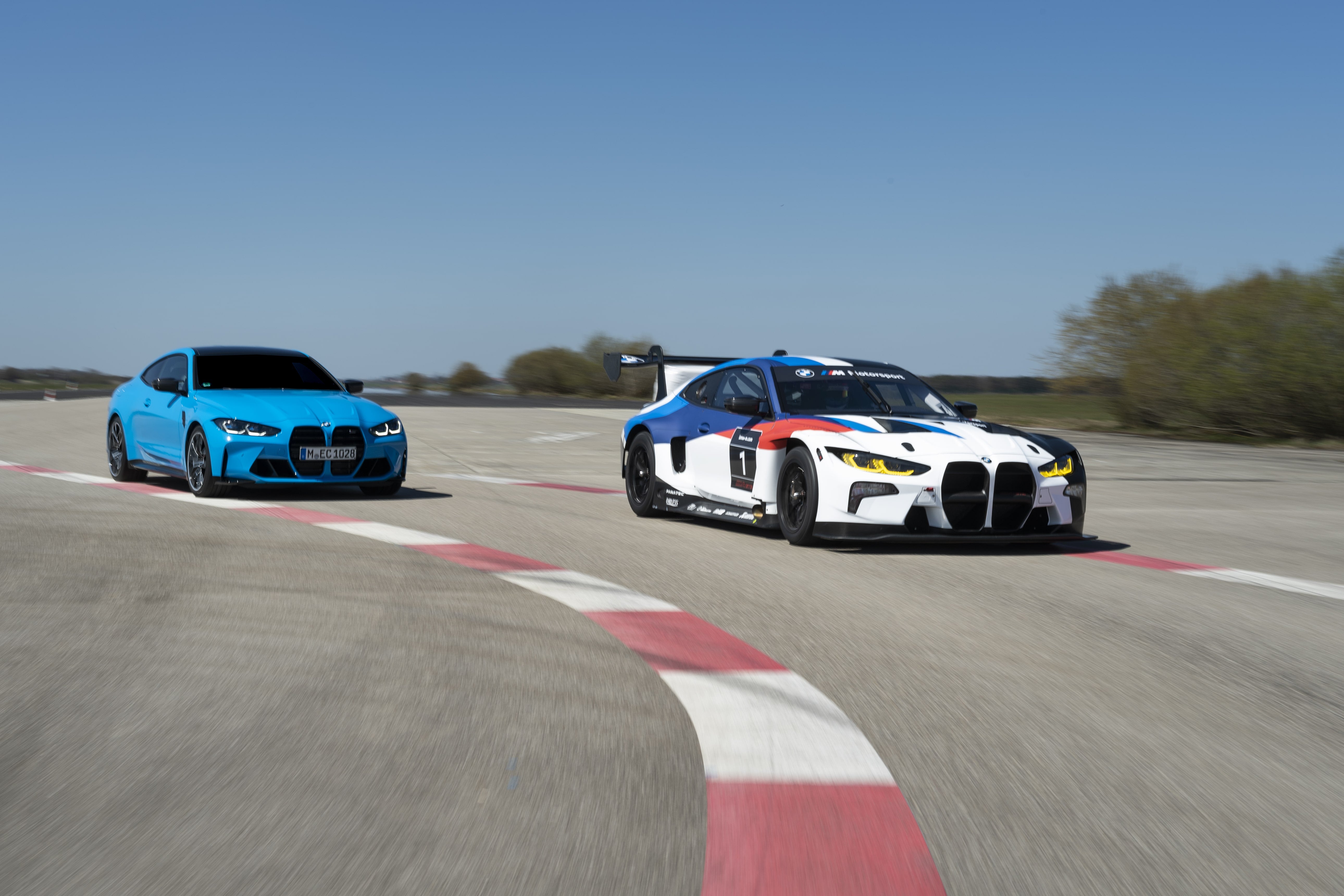 A Light Blue BMW Sedan on the Racing Track with a souped-up BMW